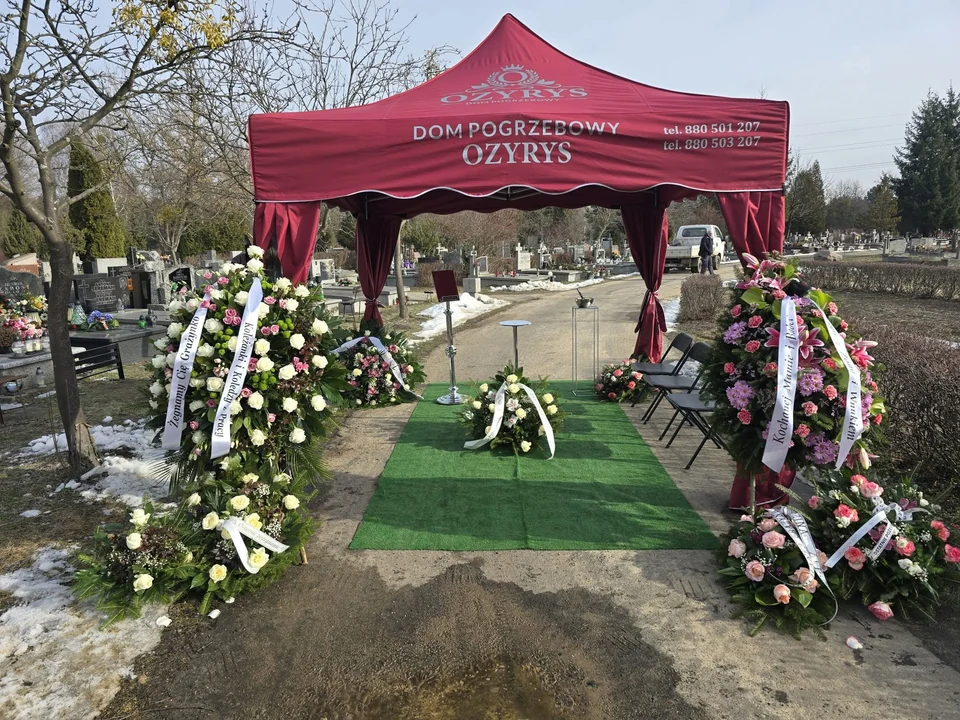 Namiot ceremonialny Ozyrys otoczony wieńcami na cmentarzu