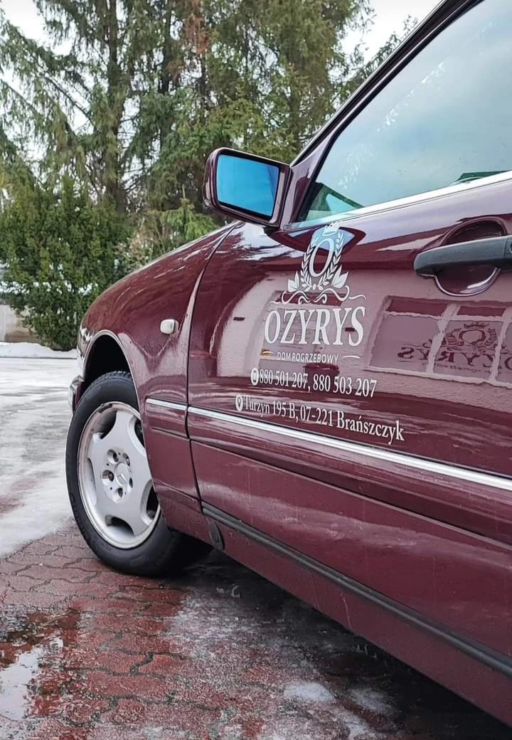 Logo Ozyrys na bordowym karawanie